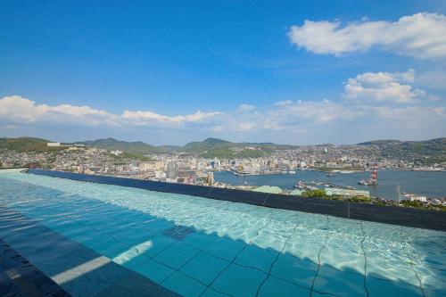 a large swimming pool with a view of a city at Ooedo Onsen Monogatari Nagasaki Hotel Seifu in Nagasaki