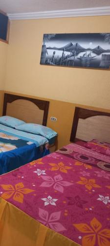 two beds sitting next to each other in a room at HOTEL PENELEU in San Pedro La Laguna