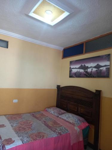 1 dormitorio con cama y techo en HOTEL PENELEU, en San Pedro La Laguna
