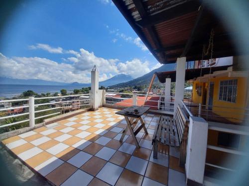 a balcony with a table and a view of the ocean at HOTEL PENELEU in San Pedro La Laguna