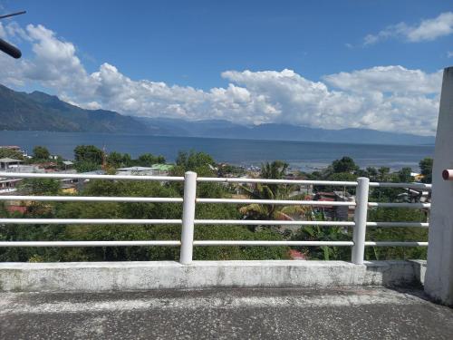 een wit hek met uitzicht op het water bij HOTEL PENELEU in San Pedro La Laguna