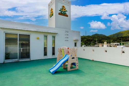 a playground on the roof of a house with a slide at Laulea YAKA in Kin