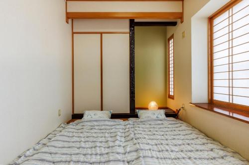 a large bed in a room with two windows at Laulea YAKA in Kin
