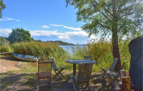 a table and chairs with a table and a boat at Awesome Home In Ronneby With Wifi in Ronneby