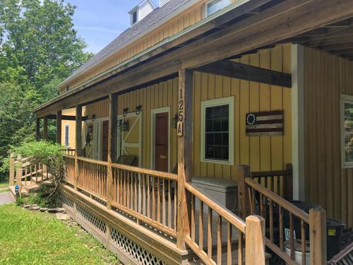 a front porch of a house with a deck at Yellow Barn Estate in Freeville