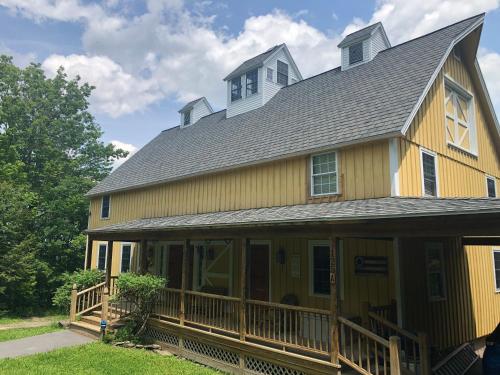 uma casa amarela com um telhado de gambrel em Yellow Barn Estate em Freeville