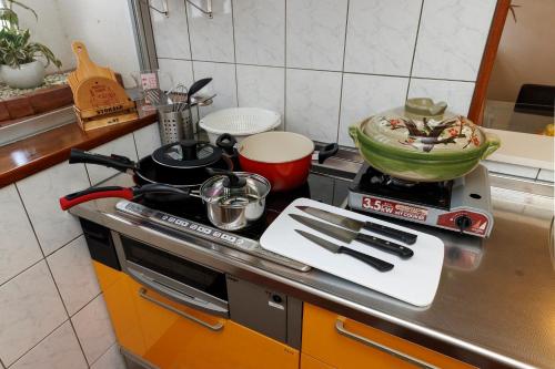 a kitchen counter with a stove with pots and pans at Laulea YAKA in Kin