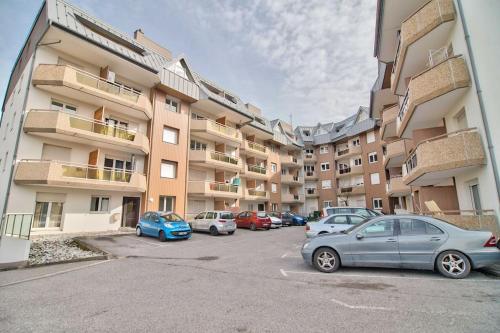 a parking lot with cars parked in front of a building at EMbnb - Studio Near Geneva - S204,4 in Étrembières