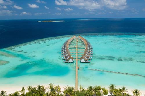 una isla en el océano con una montaña rusa en Outrigger Maldives Maafushivaru Resort en Dhangethi