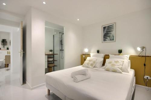 a bedroom with a large white bed with white pillows at Villa Linay in Le Diamant