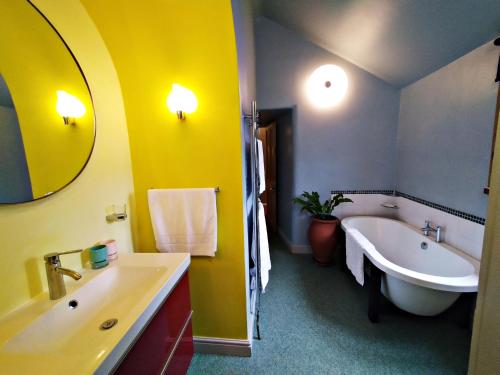 uma casa de banho com uma banheira e um lavatório e uma banheira em The Shire House em Lostwithiel