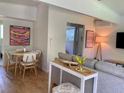 a living room with a couch and a table at Maleny Lake Cottages in Maleny