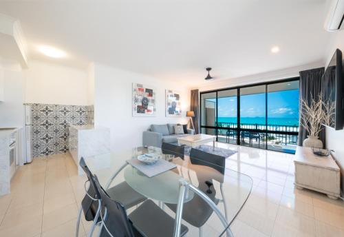 a dining room and living room with a view of the ocean at Ocean Views at Whitsunday Terraces Resort in Airlie Beach