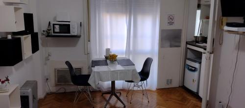 una pequeña cocina con mesa blanca y sillas en Departamento en Congreso en Buenos Aires