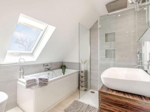 a bathroom with a white tub and a sink at Hill Crest in Dunston