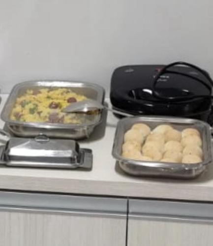 a counter with two pans of food on a counter top at Mauri Center Hotel in Picos