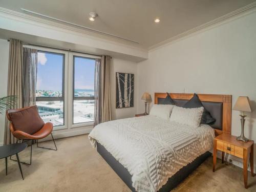 オークランドにあるSpacious 1BR Apt Parking, Gym ,Pool by Zodiak Staysのベッドと大きな窓のある寝室