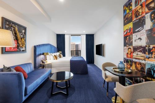 a hotel room with a couch and a bed at Avani Melbourne Jazz Corner Residences in Melbourne