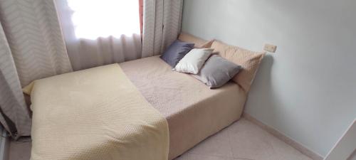 a small bed with two pillows on it in a room at Hermoso Apartamento Ubicado en Zona Céntrica de Medellín in Medellín