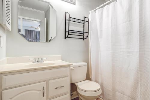 a bathroom with a toilet and a sink and a mirror at HH Beach & Tennis 240C in Hilton Head Island