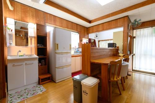 uma cozinha com uma mesa e um frigorífico em すなだの家 em Uwajima