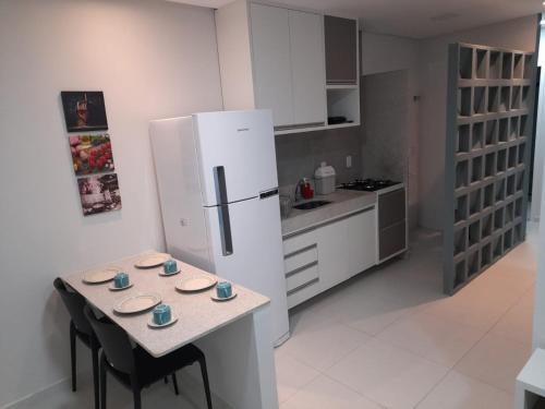 een keuken met een tafel en een witte koelkast bij FLATS TAVARES ARAUJO 202 in Garanhuns