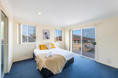 a bedroom with a bed and a large window at 1 6 Convent Lane-LJHooker Yamba in Yamba