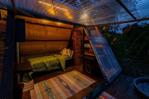 a small room with a bed and a table at Cloud Hills Glamping by Bukit Vista in Kintamani