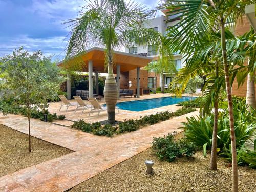 um resort com piscina e palmeiras em Apartamento Punta Cana w/Pool & Beach em Punta Cana