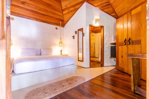 a bedroom with a white bed and a wooden ceiling at Hurricane Jeri in Jericoacoara