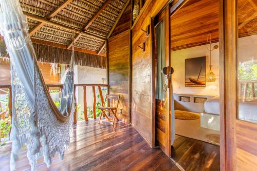 a living room with a wooden floor and a balcony at Hurricane Jeri in Jericoacoara