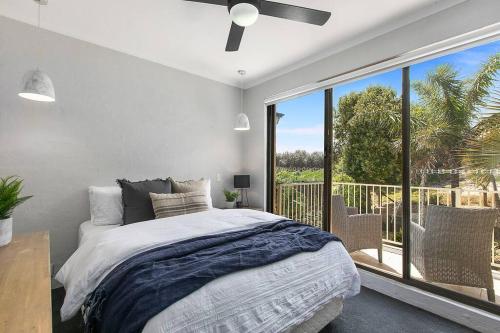 a bedroom with a bed and a large window at Between the Beach Flags, Luxury Family Hideaway - Recent Reno in The Entrance
