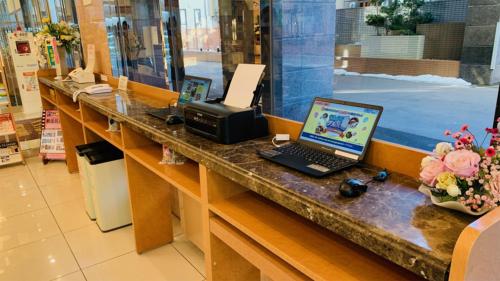 a counter with a laptop computer and a printer at Toyoko Inn Aomori Ekimae in Aomori