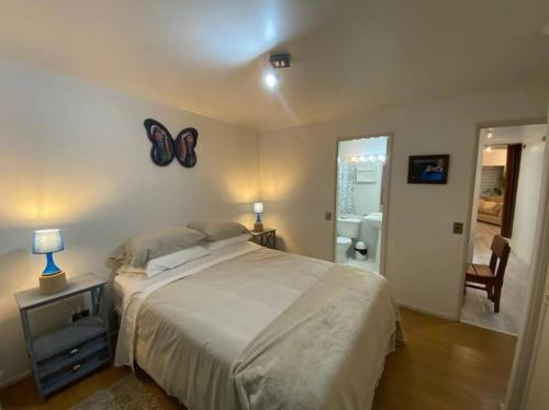 1 dormitorio con 1 cama grande con una mariposa en la pared en Acogedor bungalow house en barrio residencial, en Puerto Montt