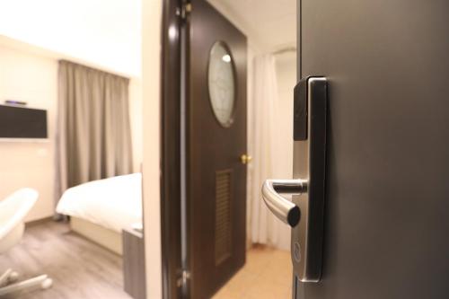 a door to a room with a bed and a bathroom at Chair Man Hotel in Taipei