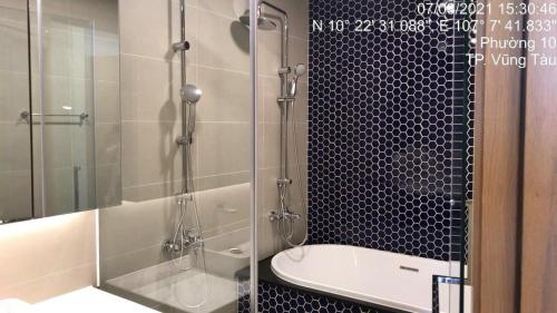 a bathroom with a shower and a tub and a toilet at Aria Resort- Căn hộ nghỉ dưỡng tầng 8 hướng biển, hồ bơi sát cạnh bãi tắm riêng (miễn phí) in Xa Thang Nhut