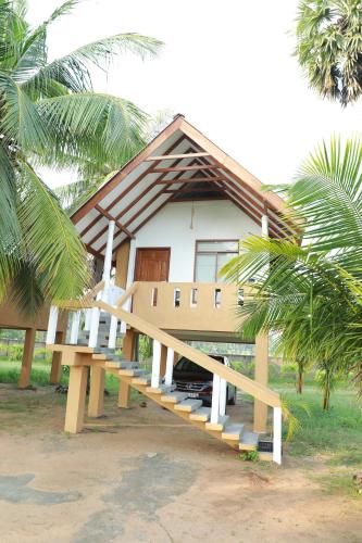 a small house with a staircase leading up to it at The Tottam Beach Hotel - Trincomalee in Trincomalee