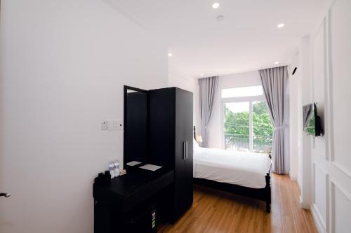 1 dormitorio con 1 cama, vestidor y ventana en The Fancy House en Quy Nhon