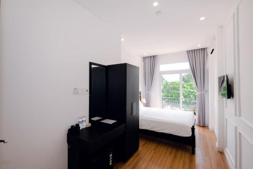 a bedroom with a bed and a dresser and a window at The Fancy House in Quy Nhon