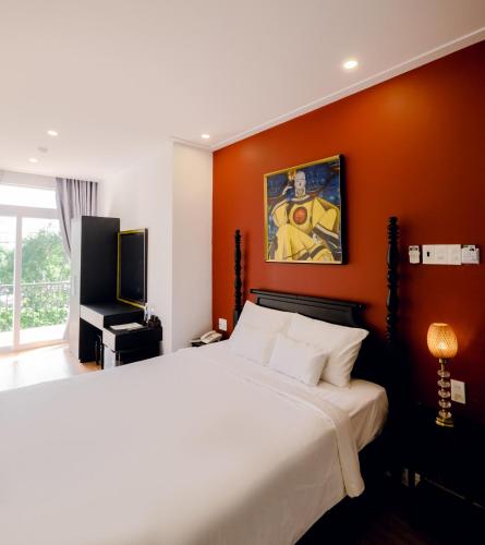 a bedroom with a bed and a painting on the wall at The Fancy House in Quy Nhon
