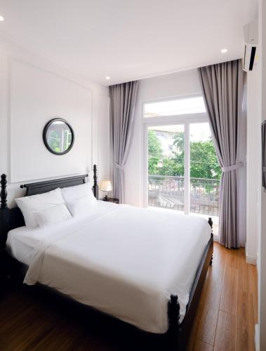 a bedroom with a large white bed and a window at The Fancy House in Quy Nhon