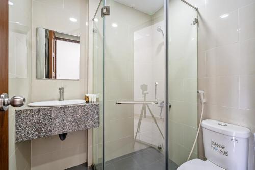 ein Bad mit einer Dusche, einem WC und einem Waschbecken in der Unterkunft AVIVA RESIDENCES in Thuan An