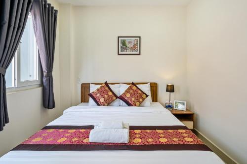 um quarto com uma cama branca e uma janela em AVIVA RESIDENCES em Thuan An