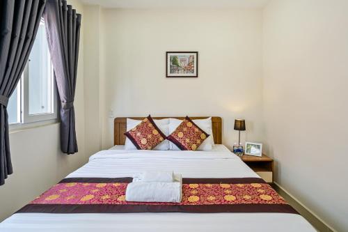 a bedroom with a white bed with a window at AVIVA RESIDENCES in Thuan An