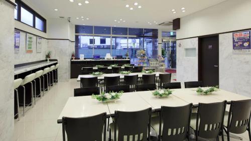 a restaurant with tables and chairs and a cafeteria at Toyoko Inn Chiba eki Higashi guchi in Chiba