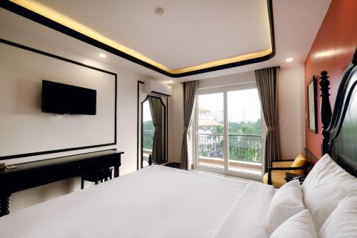 a bedroom with a large bed and a television at The Fancy House in Quy Nhon