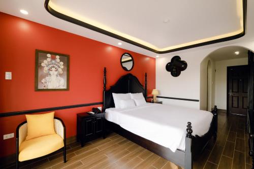 a bedroom with a large bed and orange walls at The Fancy House in Quy Nhon