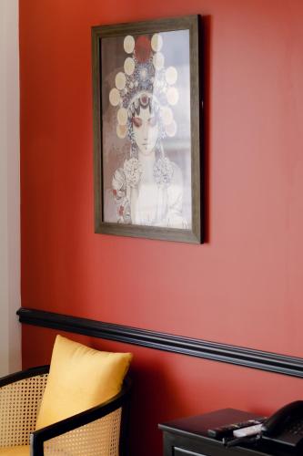 a painting of a woman on a red wall at The Fancy House in Quy Nhon