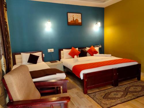 a bedroom with two beds and a chair in it at Mistywindvalley in Kudayattūr