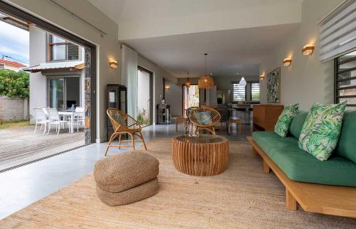 a living room with a green couch and a table at VILLA CHAMAREL in Flic-en-Flac
